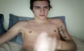 Tattooed guy jerking off until he cums on his belly